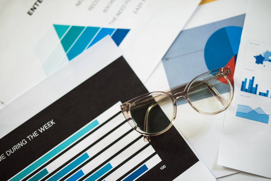 한국 금융시장 동향 — 2026년 7월 23일 — Close-up of eyeglasses resting on financial documents with various charts and graphs.