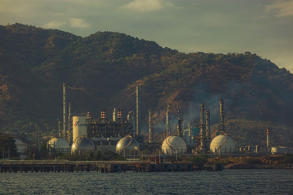 한국 금융시장 동향 (2026-07-25 작성) — Industrial factory near mountains by a river, showcasing chimneys and infrastructure.