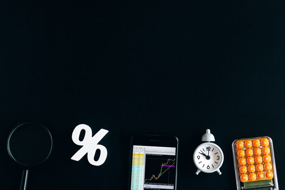 한국 금융시장 동향 — 2026년 8월 18일(화) — Flat lay of financial analysis tools including phone, clock, and calculator on black background.