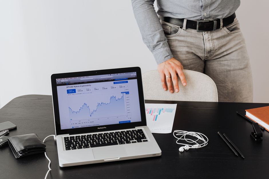 한국 금융시장 동향 — 2026년 9월 29일(화) — A businessman stands next to a laptop displaying cryptocurrency data, symbolizing modern digital finance.