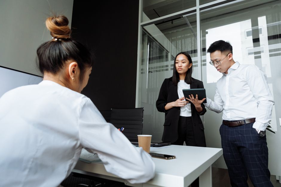 한국 금융시장 동향 — 2026년 10월 3일(토) — Three coworkers engaged in a discussion in a modern office setting with a focus on teamwork.